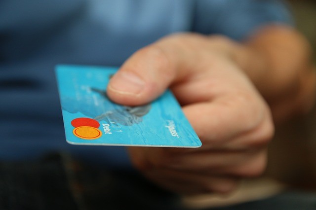 Man with credit card in hand using for pharmacy
